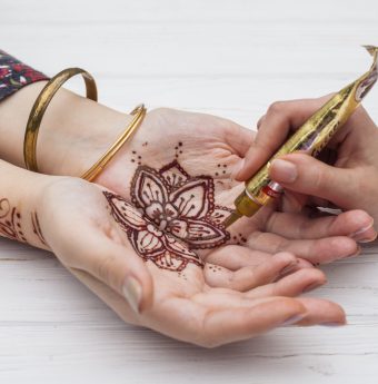 artist-making-mehndi-womans-palms